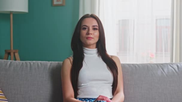 Портрет уверенной женщины, сидящей на диване — стоковое видео