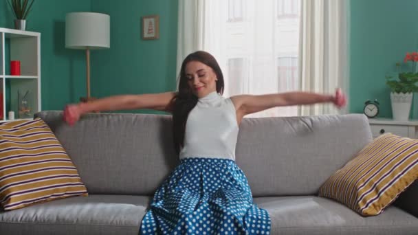 Giovane donna è seduta sul divano e stretching — Video Stock