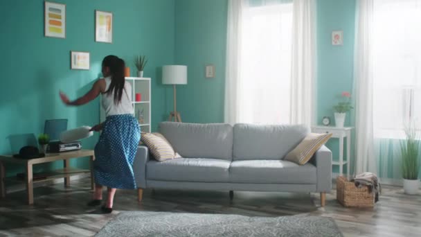 Mujer energética se divierte mientras limpia la sala de estar — Vídeo de stock