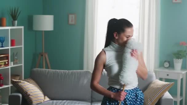 Молода жінка - домогосподарка танцює з пухким пилом — стокове відео