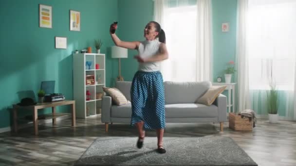 Mujer joven está grabando vídeo en el teléfono móvil y bailando — Vídeo de stock