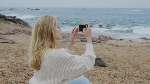 海にインスパイアされた女性が携帯電話で写真を撮っている — ストック動画