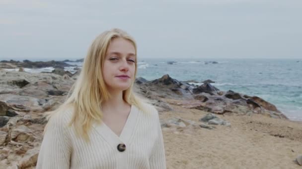 Νεαρή γυναίκα περπατά στην ακτή του ωκεανού — Αρχείο Βίντεο