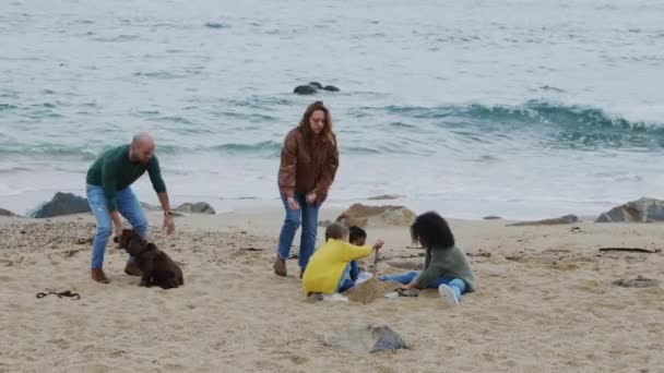 Família está construindo castelo de areia na praia — Vídeo de Stock