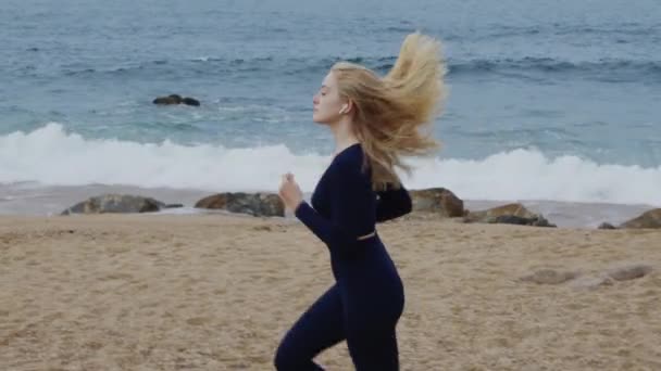 Atlético mulher está correndo na praia — Vídeo de Stock