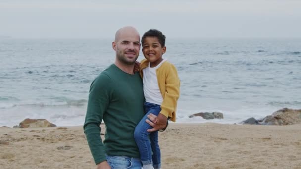 Padre joven sostiene a su hijo en sus brazos — Vídeos de Stock