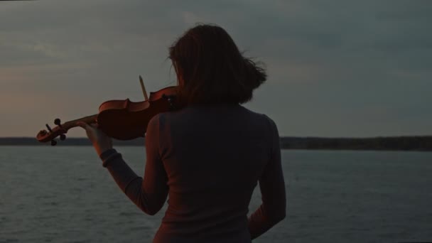 Mujer está tocando el violín al amanecer — Vídeo de stock