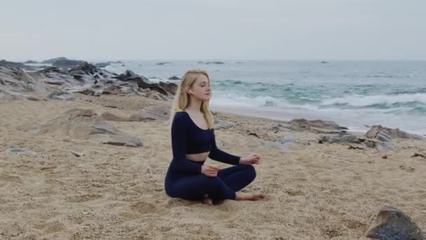 Mulher está tentando relaxar e meditar na praia — Vídeo de Stock