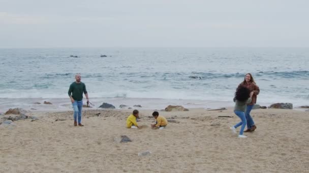 Ouders hebben plezier met kinderen aan de kust van de oceaan — Stockvideo