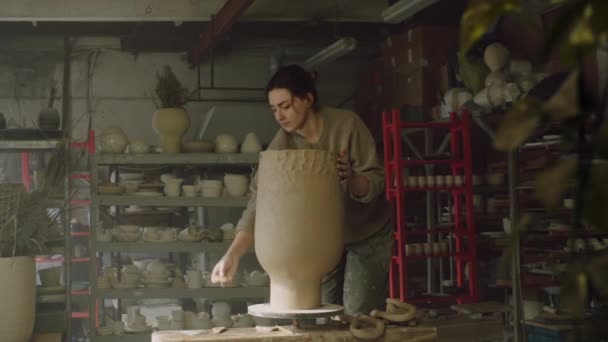 Kobieta modeluje ściany wazonu z surowej gliny — Wideo stockowe