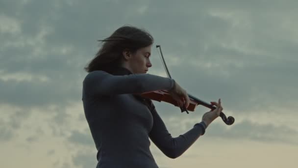女性が外で朝にバイオリンを弾いている — ストック動画