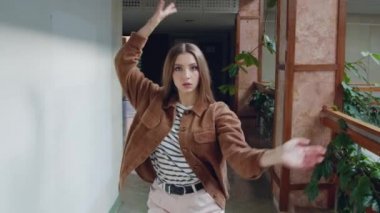 Genç kadın koridorda dans ediyor.