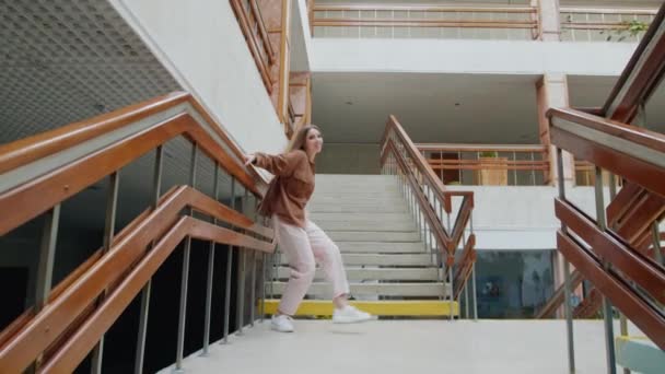 Jovem está dançando nas escadas perto da balaustrada — Vídeo de Stock