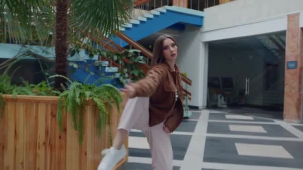 Женщина танцует рядом с клумбой — стоковое видео