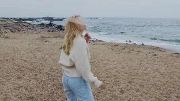 Jovem mulher está andando na costa do oceano rochoso — Vídeo de Stock