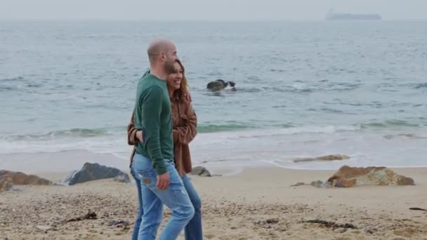 Άντρας και γυναίκα περπατούν στην ακτή του ωκεανού — Αρχείο Βίντεο