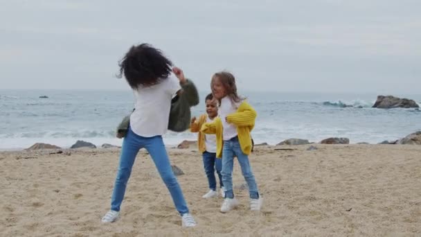 Kleine grappige kinderen dansen op het strand — Stockvideo
