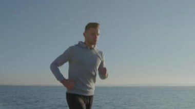 Genç adam dışarıda koşuyor.