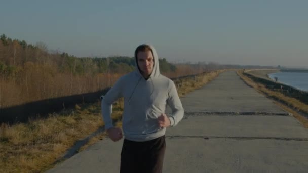 Joven hombre está corriendo al aire libre — Vídeo de stock