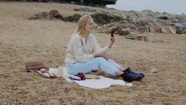 Молодая женщина записала видеообращение на пляже — стоковое видео