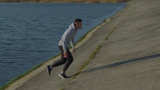 男は湖畔で心臓のトレーニングを持っています — ストック動画