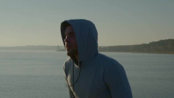 Mladý muž běží blízko jezera — Stock video