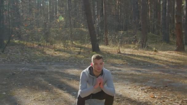 Caucasian Man Is Squatting In Forest — Stock Video