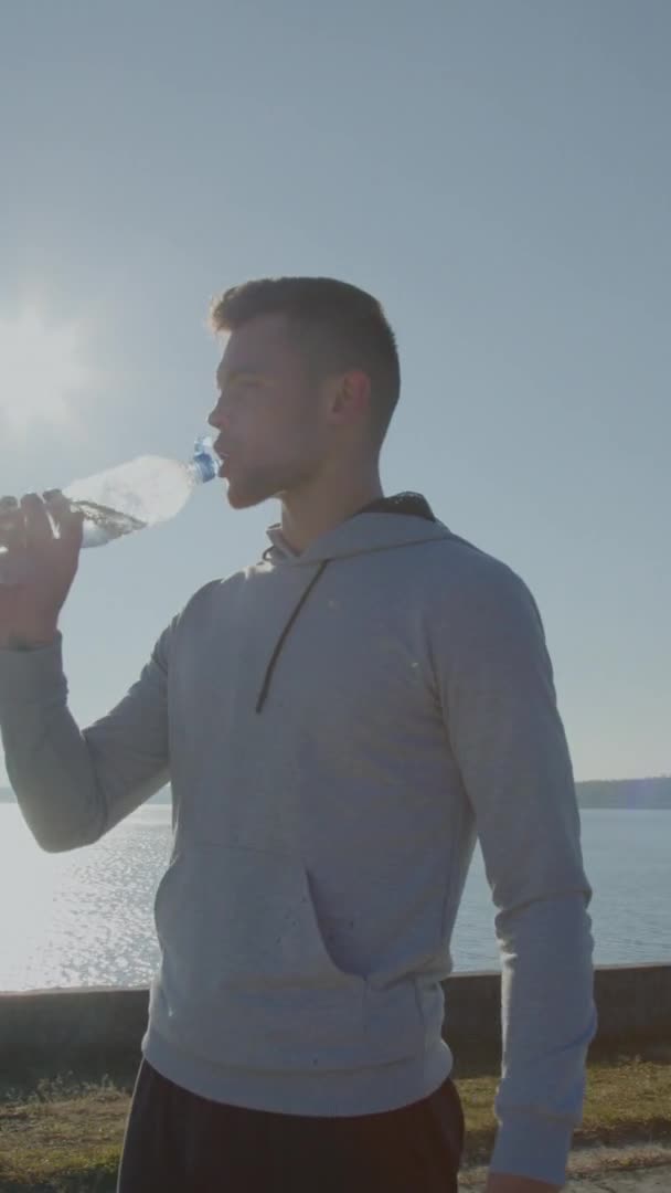 Чоловік п'є воду з пляшки — стокове відео