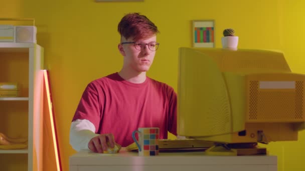 Student sitzt am Schreibtisch und scrollt Computermaus — Stockvideo