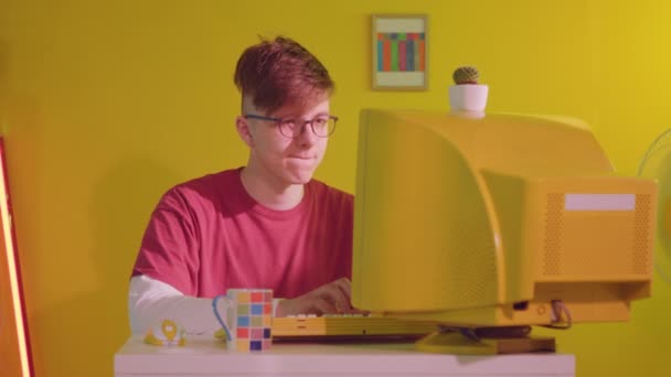 Młody informatyk pracuje w Yellow Retro Computer — Wideo stockowe