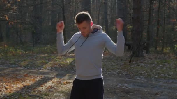 Ο άνθρωπος θερμαίνεται στο δάσος κάνοντας κύκλους χέρι — Αρχείο Βίντεο