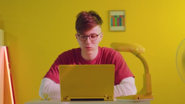 Mand studerende taler med ven online ved hjælp af bærbar computer – Stock-video