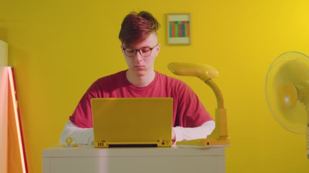 Freiberufler arbeitet an gelbem Laptop — Stockvideo