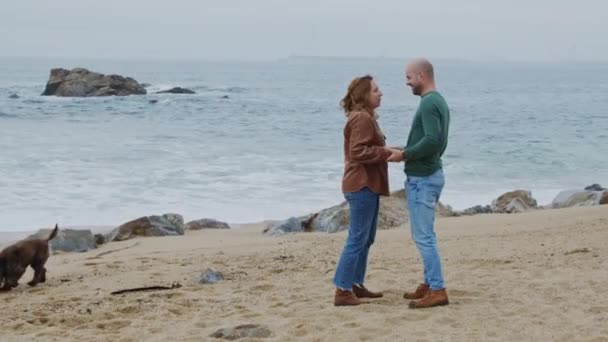 Muž a žena v lásce mají promenádu na pobřeží oceánu — Stock video