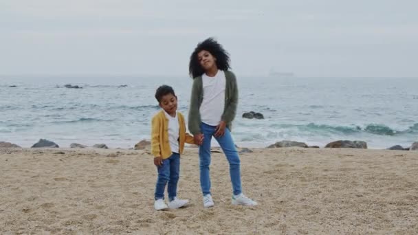 Dos hermanos graciosos están de pie en la playa — Vídeo de stock