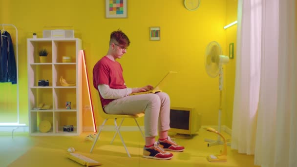 Mann tippt auf gelbem Laptop — Stockvideo