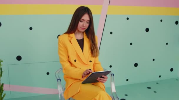 Γυναίκα με κίτρινο κοστούμι χρησιμοποιεί Gadget — Αρχείο Βίντεο