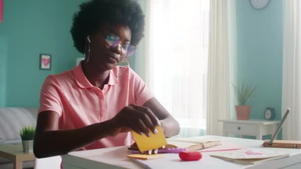 Ung afrikansk kvinna gör anteckningar medan du läser — Stockvideo