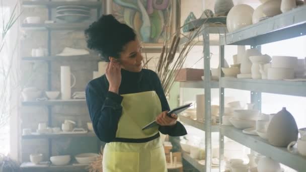 Mujer está completando pedido en línea en el almacén de cerámica — Vídeo de stock