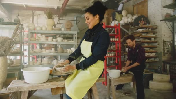Vrouw en man werken aan wielen in aardewerk studio — Stockvideo