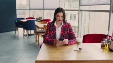 Kadın sabahını kafede geçiriyor.