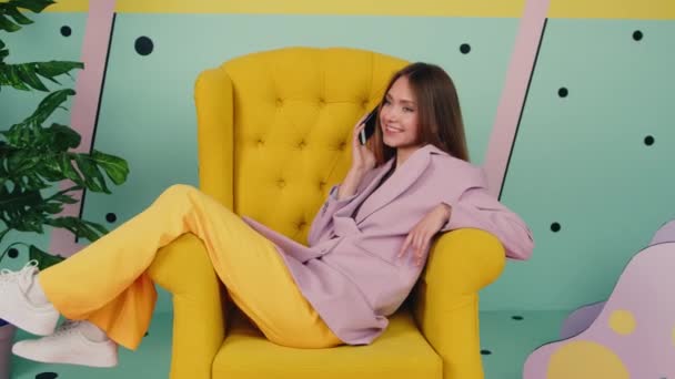 Mulher na moda terno é relaxante na poltrona — Vídeo de Stock