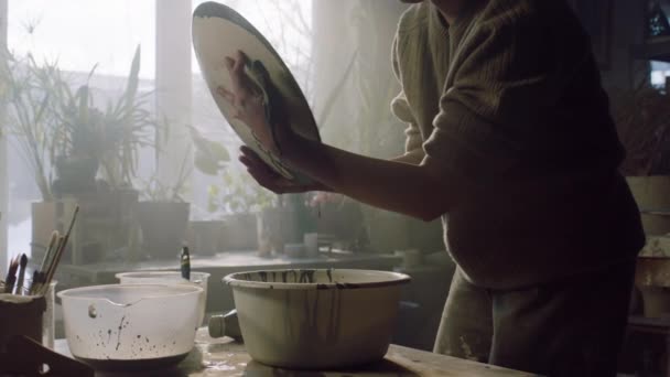 A nő zománcot terít a kerámia tányérra. — Stock videók