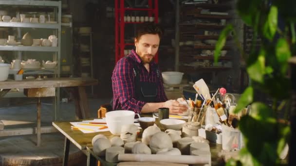 Молодий чоловік працює в студії кераміки — стокове відео