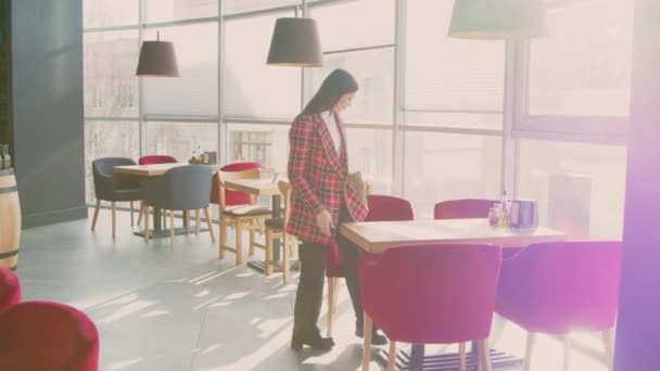 Vrouw komt in Cafe om te ontspannen — Stockvideo