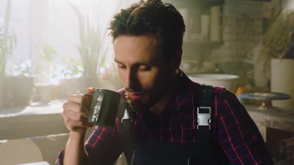 Jonge drukke man drinkt koffie — Stockvideo