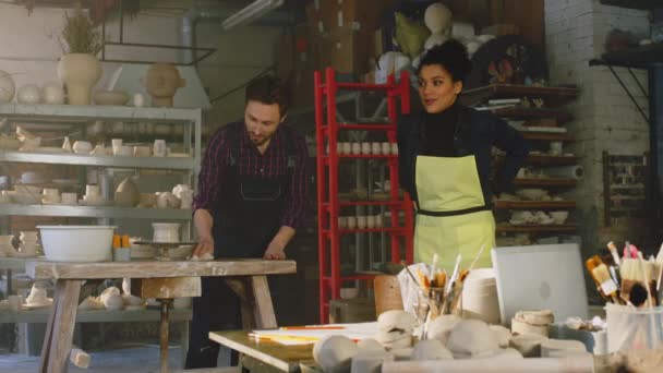 La mujer y el hombre están limpiando el estudio de cerámica — Vídeos de Stock