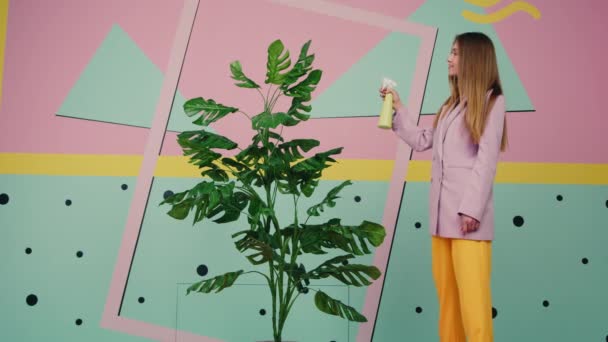 Жінка обприскує воду на домашній рослині — стокове відео