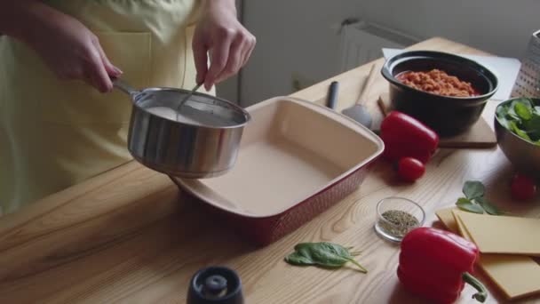 Vrouw zet saus in ovenware — Stockvideo