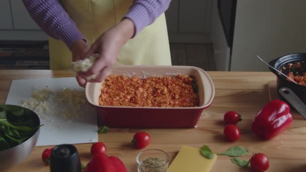 Donna sta mettendo strato di formaggio su appetitoso pasto — Video Stock